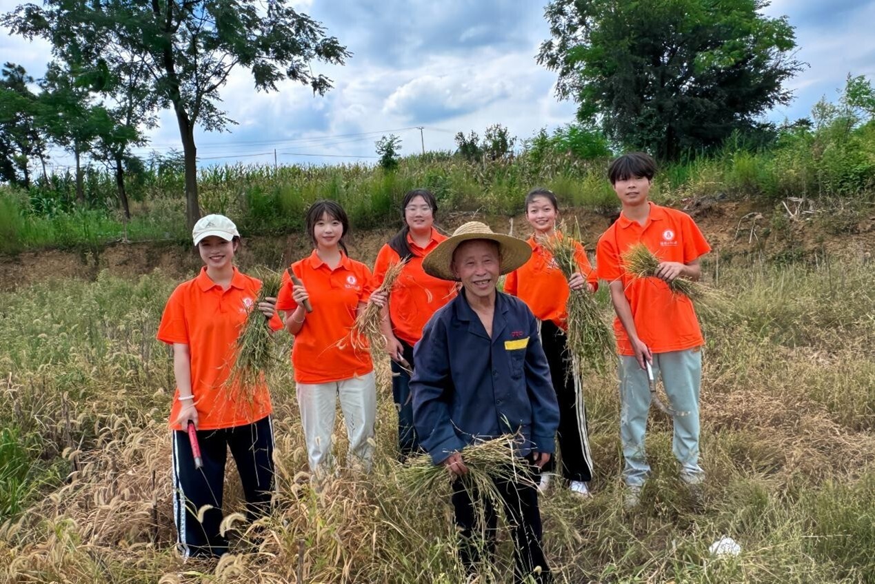图为实践小队帮助村民一起割田间杂草。蒋欣叶 摄.jpg